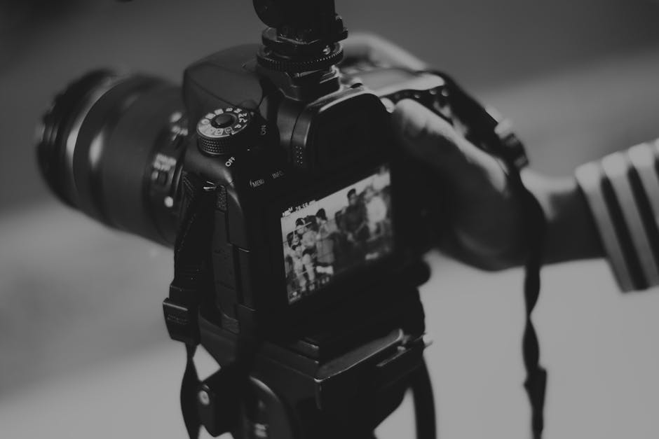Vom Band zum Digital: Wie Video8-Digitalisierung das Bewahren von Erinnerungen in München revolutioniert: Grayscale Photography of Person Holding Black Dslr Camera Grayscale Photography Of Person Holding Black Dslr Camera