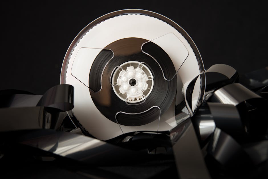 Die Top 9 Erinnerungen, die beim Super-8-Digitalisieren wieder zum Leben erwachen: Vintage plastic bobbin with unrolled film for cinematography industry placed on black background Vintage Plastic Bobbin With Unrolled Film For Cinematography Industry Placed On Black Background